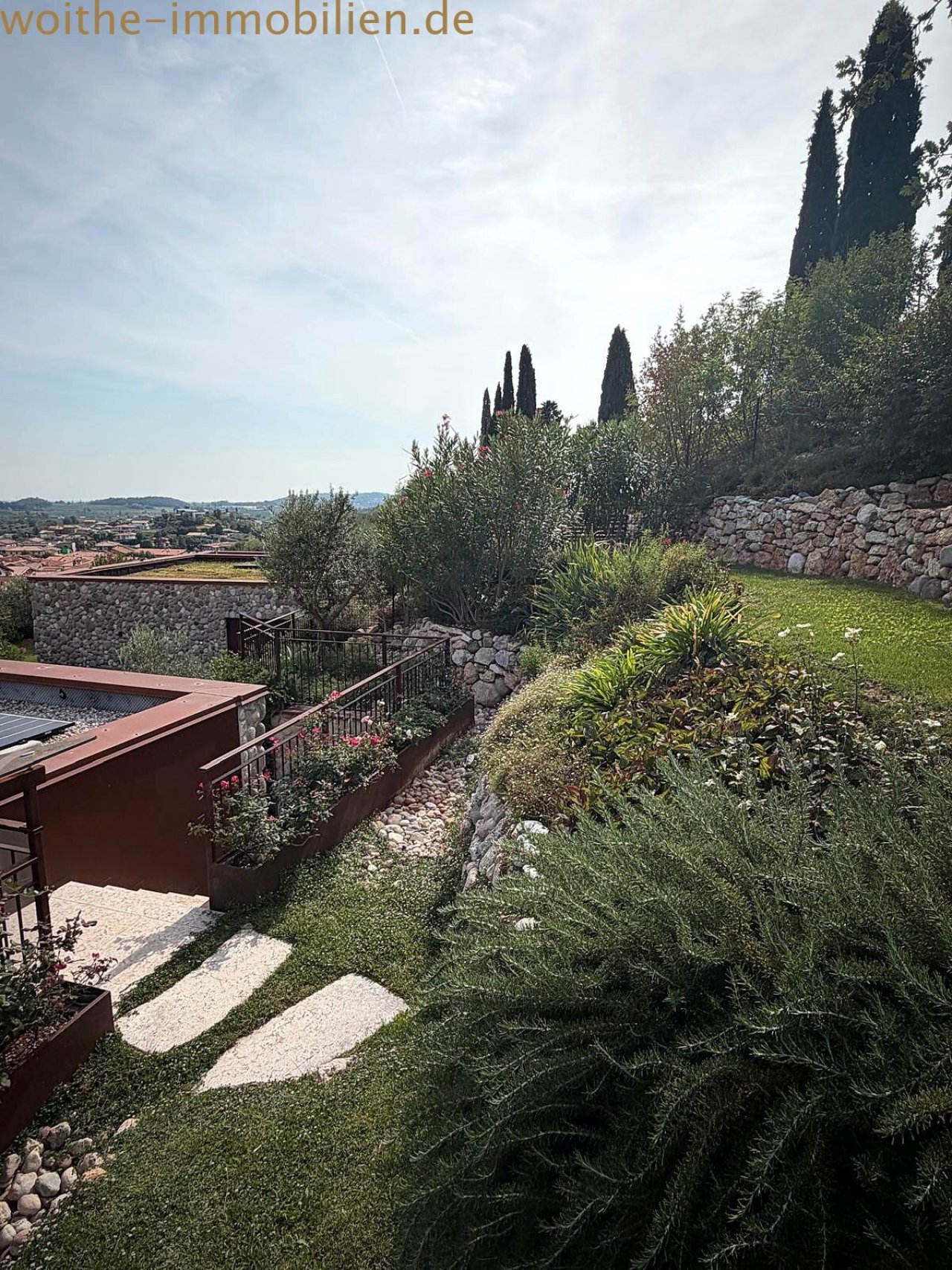 Terrassengarten mit Natursteinmauern und Panoramablick – Ideal für entspannte Außenbereiche