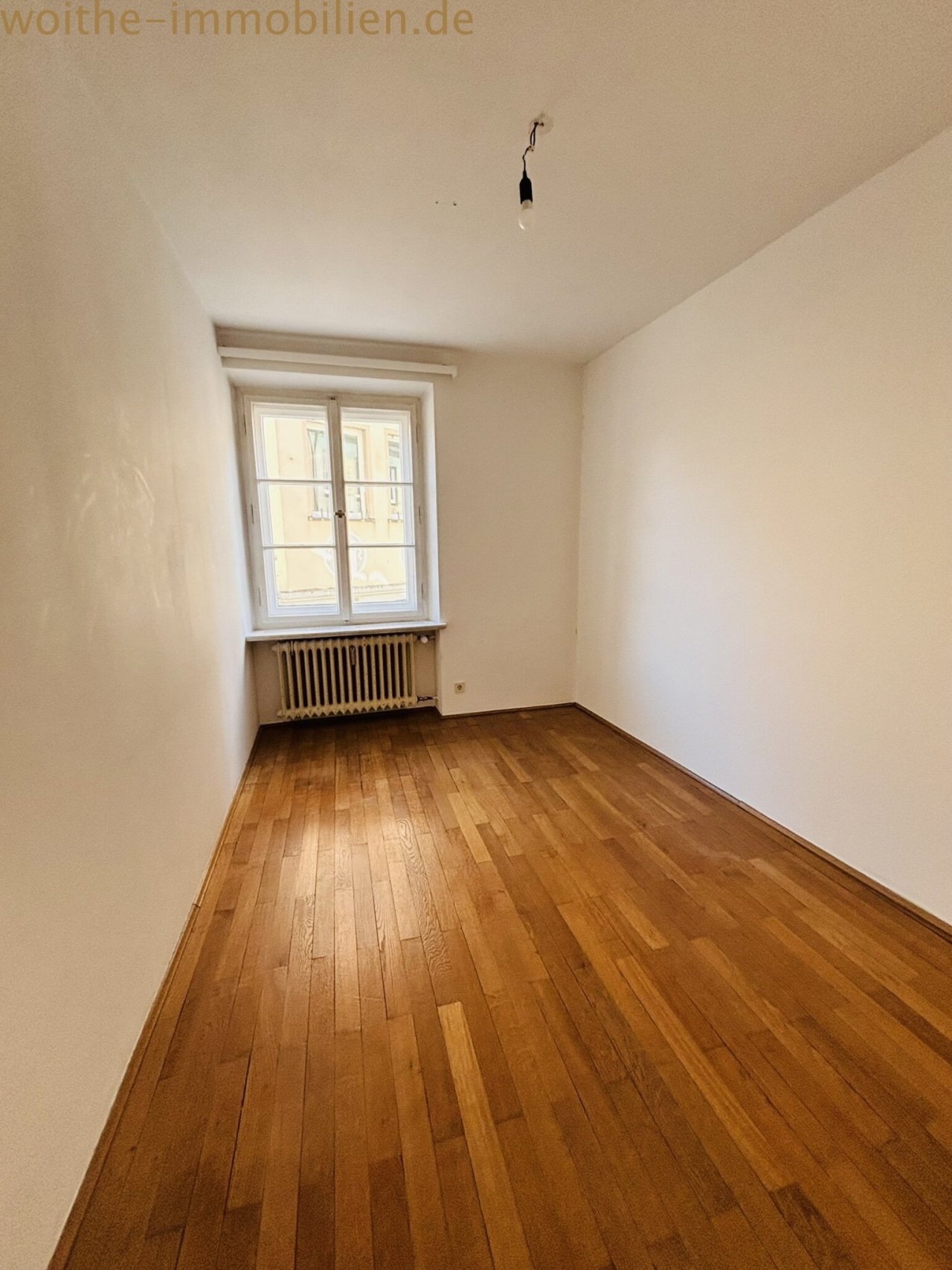 Airy room with elegant parquet flooring and optimal light supply through large window Airy room with elegant parquet flooring and optimal light supply through large window